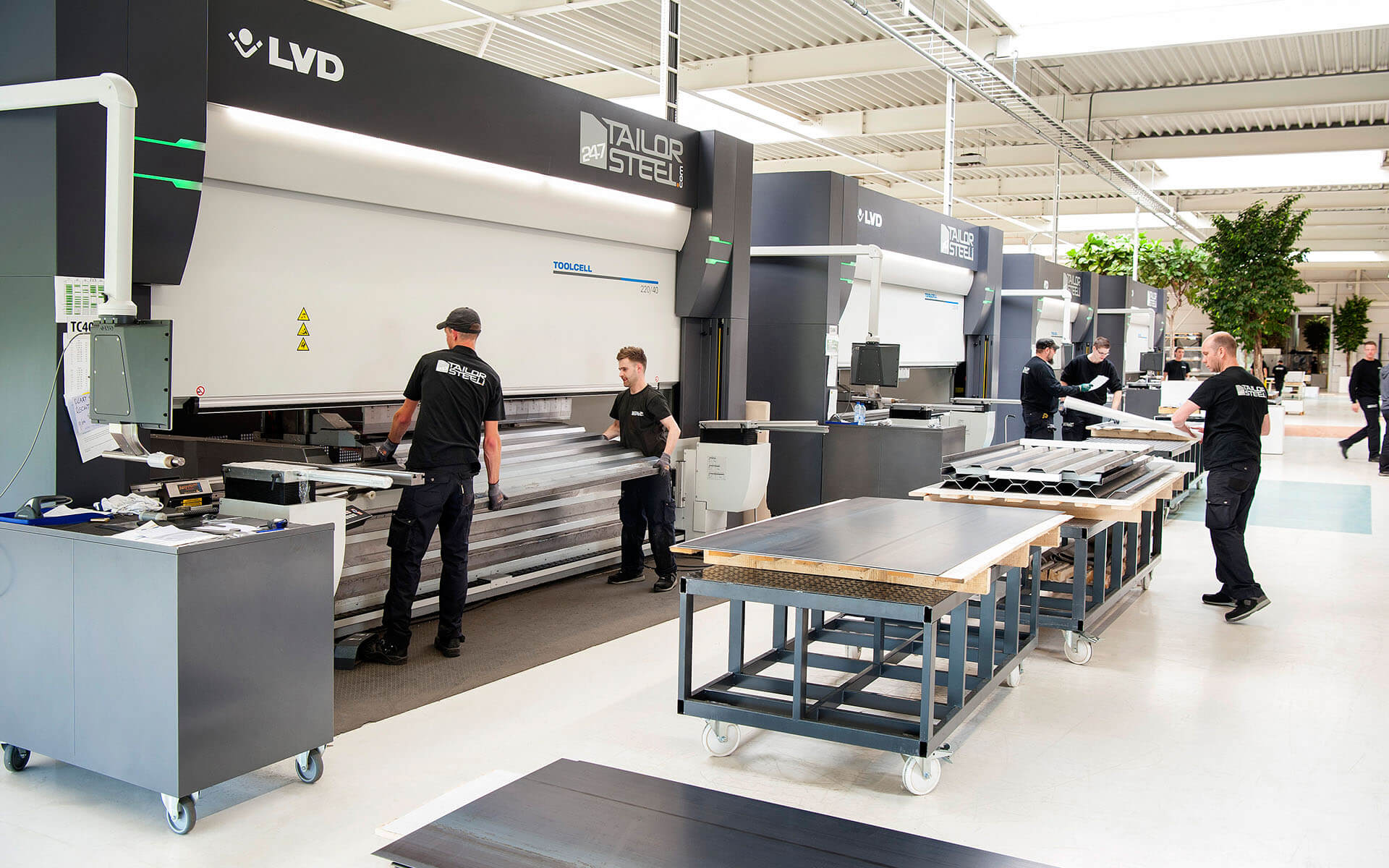 Een AGV voert materiaal aan bij een lasermachine Een AGV voert materiaal aan bij een lasermachine
