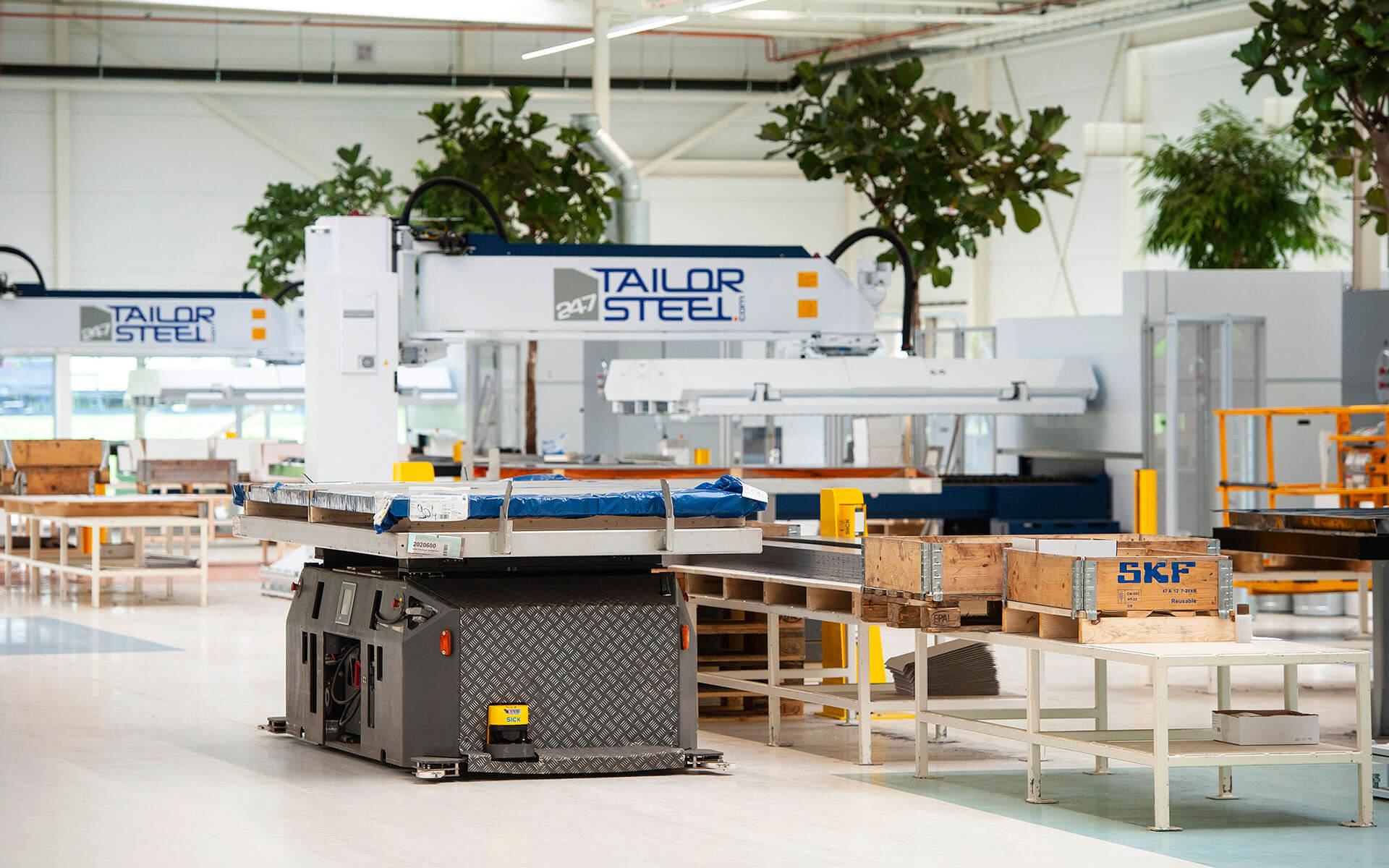 Een AGV voert materiaal aan bij een lasermachine Een AGV voert materiaal aan bij een lasermachine